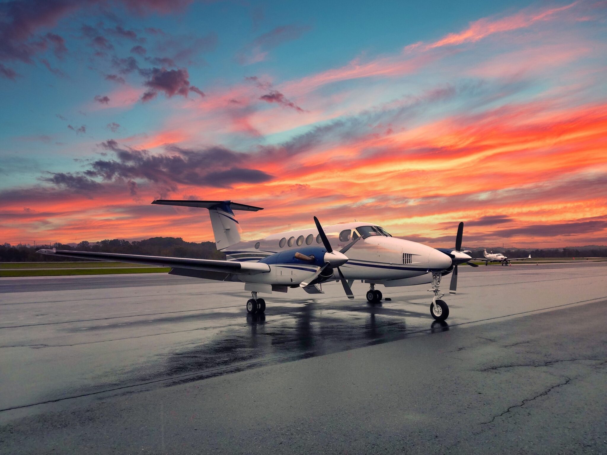 Beechcraft King Air turboprop on a wet ramp at sunset