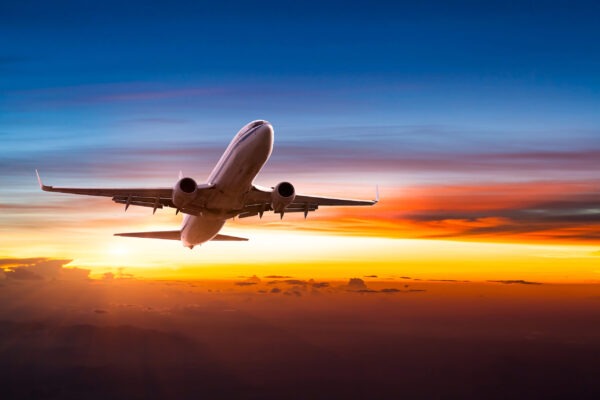 Airliner climbing above the clouds at sunset